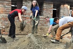 Volunteer Nepal Local children in Nepal look on excitedly while volunteers help with building classrooms for a school damaged during the 2015 earthquake.