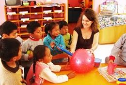 Volunteer Care A Care & Community volunteer sits with children at a placement in Peru