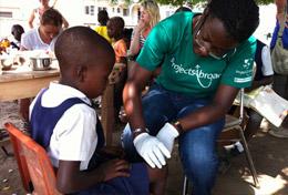 Volunteer Medicine and Healthcare A Public Health Project volunteer works with a child during a public outreach in Ghana