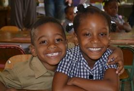 Volunteer Jamaica Two children smile for a photo at a French Teaching volunteer placement in Jamaica